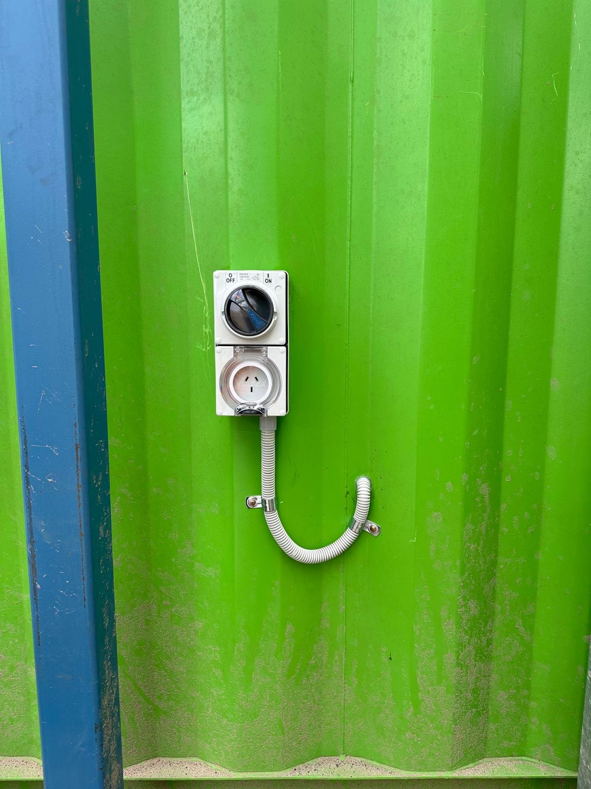 Weather-protected industrial power outlet and isolation switch installed on a commercial premises